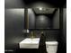 Chic powder room features black walls, modern sink, gold fixtures and decorative mirror at 3640 E Fairmount Ave, Phoenix, AZ 85018