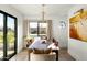 Bright dining room with modern light fixture, neutral colored walls, a view to the outdoors and an accent painting at 3640 E Fairmount Ave, Phoenix, AZ 85018