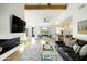 Open-concept living area with a modern fireplace, wood floors, and a view to the kitchen and outdoor space at 3640 E Fairmount Ave, Phoenix, AZ 85018