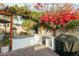 Outdoor kitchen with built-in grill, counter space, and lush bougainvillea at 3640 E Fairmount Ave, Phoenix, AZ 85018
