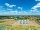 Expansive aerial view featuring a lake, agricultural fields, and distant residential areas under a partly cloudy sky at 4064 E Morrison Ranch Pkwy, Gilbert, AZ 85296
