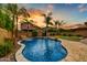 Gorgeous backyard pool with waterfall feature, lush landscaping, and desert sunset views at 4064 E Morrison Ranch Pkwy, Gilbert, AZ 85296