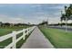 Image of a paved walking path alongside a white fence and lush greenery at 4064 E Morrison Ranch Pkwy, Gilbert, AZ 85296