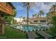 Expansive backyard featuring a refreshing pool, lounge chairs, mature palm trees, and a unique treehouse at 4701 E Calle Redonda St, Phoenix, AZ 85018