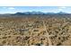 Vast desert landscape with scattered homes and roads, set against a mountain backdrop at 53573 W Fresno Rd, Maricopa, AZ 85139