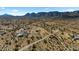 Wide aerial view of neighborhood properties with desert landscaping, fenced perimeters and mountain backdrop at 53573 W Fresno Rd, Maricopa, AZ 85139