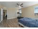 Bedroom with wood floors, large windows for natural light, and open access to the home's additional rooms at 53573 W Fresno Rd, Maricopa, AZ 85139