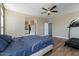 Cozy bedroom with wood floors, ceiling fan, and convenient access to an ensuite bathroom with a walk-in shower at 53573 W Fresno Rd, Maricopa, AZ 85139