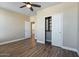 Comfortable bedroom featuring wood-look floors, a ceiling fan, and an attached closet at 53573 W Fresno Rd, Maricopa, AZ 85139