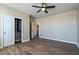 Well-lit bedroom with wood-look flooring, ceiling fan, and closet for storage at 53573 W Fresno Rd, Maricopa, AZ 85139