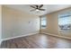 Serene bedroom featuring wood-look floors, a ceiling fan, and bright windows at 53573 W Fresno Rd, Maricopa, AZ 85139