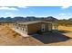 Side view of a single-story home with a gravel yard and mountain views at 53573 W Fresno Rd, Maricopa, AZ 85139