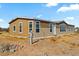 View of the side of the house with neutral siding, many windows, and desert landscaping at 53573 W Fresno Rd, Maricopa, AZ 85139