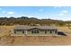 Charming single-story home with neutral siding and many windows showcasing natural light with a mountain backdrop at 53573 W Fresno Rd, Maricopa, AZ 85139