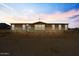 Charming single-story home with large windows, nestled against a beautiful sunset backdrop at 53573 W Fresno Rd, Maricopa, AZ 85139