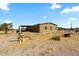 View of the side of the house with neutral siding showing covered parking and desert landscaping at 53573 W Fresno Rd, Maricopa, AZ 85139