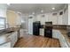 A spacious kitchen area featuring white cabinets, tile backsplash, and black appliances at 53573 W Fresno Rd, Maricopa, AZ 85139