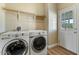 Functional laundry room featuring side-by-side washer/dryer and a convenient outdoor access door at 53573 W Fresno Rd, Maricopa, AZ 85139
