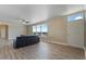 Cozy living room featuring natural light from large windows, wood flooring, neutral walls, and direct outdoor access at 53573 W Fresno Rd, Maricopa, AZ 85139