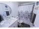 Cozy bathroom featuring a round mirror, patterned shower curtain, and a pristine white vanity at 5458 W El Caminito Dr, Glendale, AZ 85302