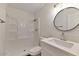 Bathroom showcasing a tiled shower and modern vanity with circular mirror and lighting at 5458 W El Caminito Dr, Glendale, AZ 85302