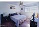 Well-lit bedroom with a ceiling fan and large window overlooking a carpeted floor at 5458 W El Caminito Dr, Glendale, AZ 85302