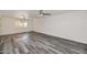 Bright living room with gray wood flooring and contemporary ceiling fans at 5458 W El Caminito Dr, Glendale, AZ 85302