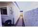 Narrow side yard with concrete walkway and gravel leading to a wooden gate at 5458 W El Caminito Dr, Glendale, AZ 85302