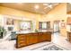 Open kitchen with an eat-in island featuring stone countertops, a sink, and a ceiling fan at 6347 E Old West Way, Cave Creek, AZ 85331