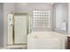 Serene bathroom featuring a soaking tub and separate glass-enclosed shower at 6931 W Antelope Dr, Peoria, AZ 85383