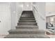 Carpeted staircase features neutral colored walls, white trim, and access to the upper level of the home at 6931 W Antelope Dr, Peoria, AZ 85383