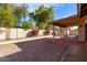 Backyard featuring a covered patio, gravel landscaping, and block wall for additional privacy at 7454 E Pueblo Ave, Mesa, AZ 85208