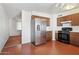 Kitchen with tile floors, wood cabinets, stainless steel refrigerator, black stove, and white countertops at 7538 E Carol Cir, Mesa, AZ 85208