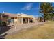 Rear exterior view of this property with a covered patio, desert landscaping, and golf course views at 7861 E Fountain Cv, Mesa, AZ 85208