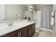 Well-lit bathroom vanity with a large mirror, modern sink, and dark wood cabinets at 8516 W Peppertree Ln, Glendale, AZ 85305