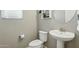 The bathroom features a white toilet and sink with chrome fixtures and white floating shelves at 8516 W Peppertree Ln, Glendale, AZ 85305
