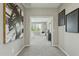 The hallway is decorated with artwork and leads into a bedroom with neutral paint, carpet, and lots of natural light at 8516 W Peppertree Ln, Glendale, AZ 85305