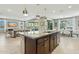 This open kitchen has a large island with granite counters and stainless steel appliances and flows into the dining and living rooms at 8516 W Peppertree Ln, Glendale, AZ 85305