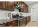 A kitchen features granite counters, dark wood cabinets, stainless appliances, and a white subway tile backsplash at 8516 W Peppertree Ln, Glendale, AZ 85305