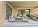 Inviting covered patio featuring stylish seating and an open doorway to the home's interior at 8516 W Peppertree Ln, Glendale, AZ 85305