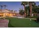 Expansive backyard featuring a putting green, pool with waterfall, and mature trees at 9128 N 70Th St, Paradise Valley, AZ 85253