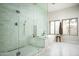 Modern bathroom with glass shower and soaking tub, bright interior, and backyard views at 9128 N 70Th St, Paradise Valley, AZ 85253