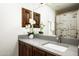 Bathroom featuring dark wood cabinets, gray quartz countertops, a modern sink and decorative orchids at 9128 N 70Th St, Paradise Valley, AZ 85253