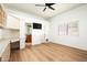 Spacious bedroom with light wood floors, a TV, built-in desk, and an ensuite bathroom at 9128 N 70Th St, Paradise Valley, AZ 85253
