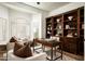 Bright home office with custom built-ins, a large desk, and comfortable seating by the shuttered windows at 9128 N 70Th St, Paradise Valley, AZ 85253