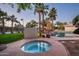 Tranquil backyard hot tub with landscaping and view of pool, tennis court, and lush greenery at 9128 N 70Th St, Paradise Valley, AZ 85253