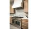 Spacious kitchen features professional range with oversized hood, light wood cabinetry and stylish marble counter tops at 9128 N 70Th St, Paradise Valley, AZ 85253