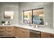 Bright kitchen boasts gray tile backsplash, marble countertops, light wood cabinetry, and a window with a view of the pool at 9128 N 70Th St, Paradise Valley, AZ 85253