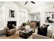 Bright, open living room features a cozy fireplace, plush seating, modern ceiling fan, and seamless access to dining space at 9128 N 70Th St, Paradise Valley, AZ 85253