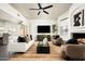 Bright, open living room features a cozy fireplace, plush seating, modern ceiling fan, and seamless access to dining space at 9128 N 70Th St, Paradise Valley, AZ 85253